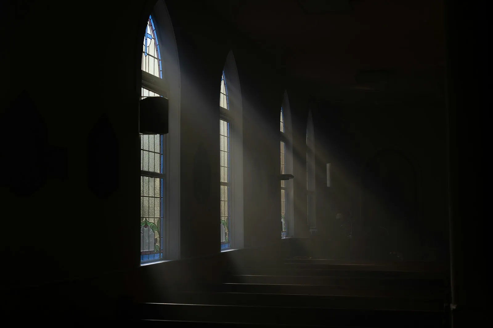 Sunlight streaming through windows into a dark room
